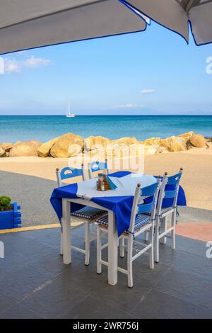 Table with chairs in Greek seaside restaurant. Kardamena village on the island of Kos, Greece Stock Photo