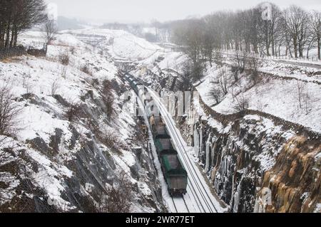 08/03/18  A freight train passes through a cutting lined with icicles  near Doveholes after snow returns to the Derbyshire Peak District.  All Rights Stock Photo