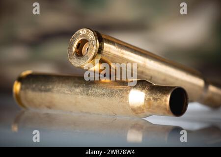 Demounted bullet shells on camouflage background closeup Stock Photo