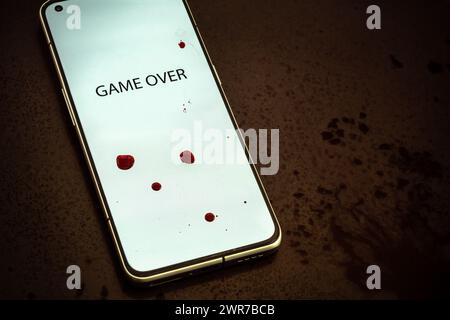 Image of game overwords inscription on phone screen bloodstains splashes and spots background horror dark mood Stock Photo