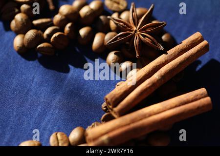 Coffee beans, star anise an cinnamon spices on deep blue background Stock Photo