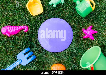 close up of sand toys kit on green lawn or grass Stock Photo