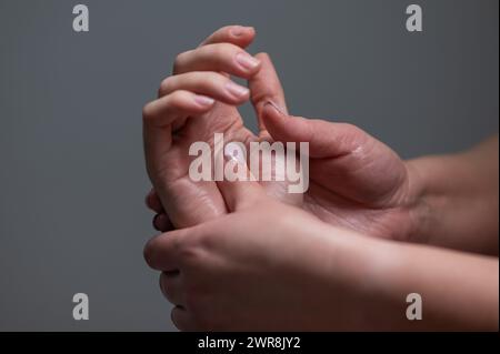 The masseuse massages the client's palms. Close-up of hands at a spa treatment.  Stock Photo