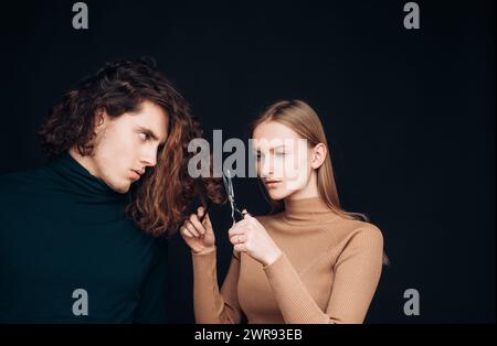 Family crisis. Girl scheming an evil plan of cutting off a curly hair in a man. A smart wily woman has wonderful schemes like a crook of a friend, a Stock Photo