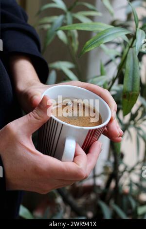 Step into a world of warmth and tradition as Greek coffee brews gently on a small gas burner, reminiscent of the beloved Turkish coffee ritual. Stock Photo
