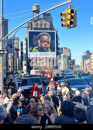 Crowds of people walk along Canal Street on Chinese New Year with a prominant Apple Iphone billboard in the background. Stock Photo