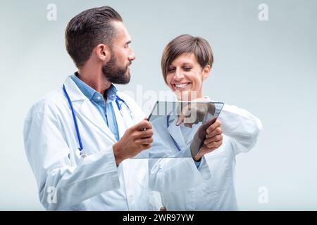 Medical team examines patient data on a transparent device, showcasing integration of AI in healthcare Stock Photo