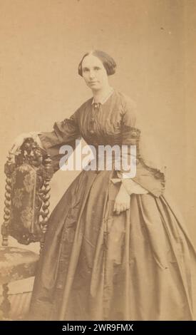 Portrait of a woman standing by a chair, This photo is part of an album., Henri Pronk, 1850 - 1867, cardboard, albumen print, height 82 mm × width 50 mm, photograph Stock Photo