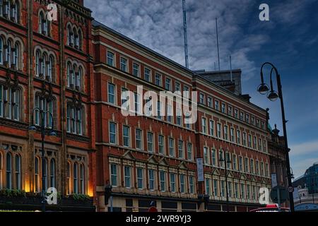 Historic red brick building at dusk with street lamp and dramatic sky in Leeds, UK. Stock Photo