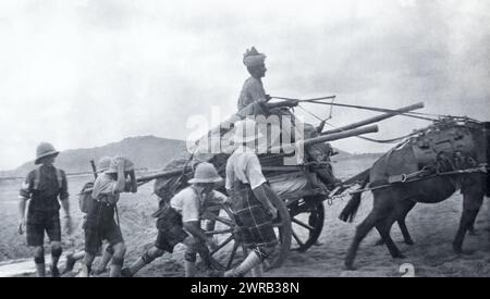 Soldiers of the 2nd Battalion Highland Light Infantry pushing a cart uphill in British India, c. 1925. Stock Photo