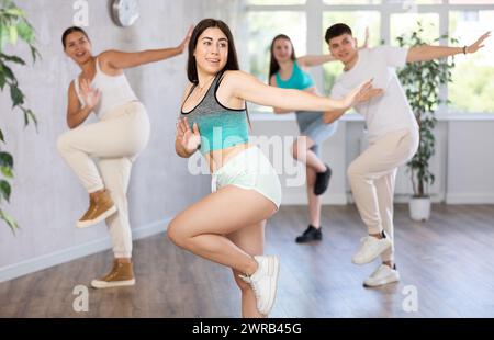 Teenagers practicing breakdance toprock moves in training hall. Teenagers engaged in breakdance Stock Photo
