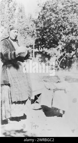 Armenian children begin to make themselves useful at an early age, Photograph shows Armenian or Greek woman holding ball of yarn, as child holds two spindles., between 1915 and 1923, Near East Relief (Organization), 1910-1930, Photographic prints, 1910-1930., Photographic prints, 1910-1930, 1 photographic print Stock Photo