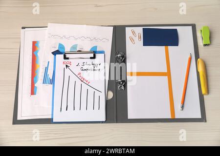 Business process planning and optimization. Documents with different types of graphs and stationery on wooden table, above view Stock Photo