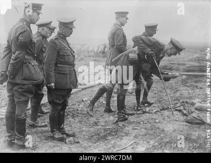 King Albert on Battle Field, Photograph shows an aide-de-camp of King Albert I of Belgium picking up a souvenir on the Somme battlefield near Pozieres, France, May 16, 1917. King Albert I and General Hubert Gough, the British Commander of the Fifth Army stand in background., 1917 May 16, World War, 1914-1918, Glass negatives, 1 negative: glass Stock Photo