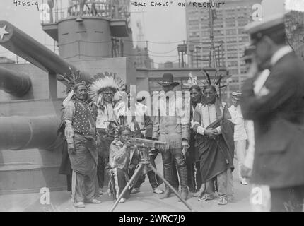 Chief Bald Eagle on RECRUIT, Photograph shows a group of Native Americans inspecting the model weapons aboard the USS Recruit, a wooden mockup of a battleship built in Union Square, New York City by the Navy to recruit seamen and sell Liberty Bonds during World War I., 1917 July 28, World War, 1914-1918, Glass negatives, 1 negative: glass Stock Photo