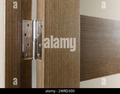 Door hinge on a wooden interior door with glass inserts. Stock Photo