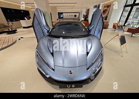 SHANGHAI, CHINA - MARCH 12, 2024 - Customers experience the YANGWANG U9 supercar model of BYD's pure electric new energy vehicle brand at the YANGWANG Stock Photo