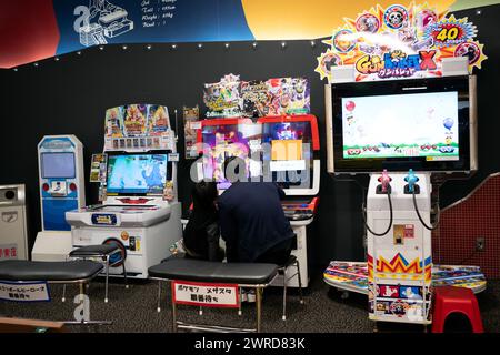 Father and son playing together at an arcade amusement game center in Japan Stock Photo