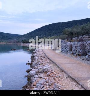 Path and calm sea near Cres Croatia after sunset in springtime Cres Croatia Stock Photo