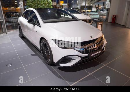 new white electric Mercedes EQE 53 sedan, car in showroom, EV Mercedes-Benz Group, environmental cleanliness vehicle, Innovation in automotive industr Stock Photo