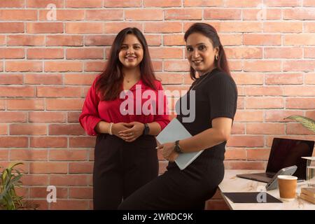 Portrait of two smiling businesswomen standing and looking at camera Stock Photo