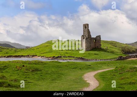 Ardvreck Castle's ruins, embraced by the lush Scottish Highlands, are reached by an arabesque S-shaped path that gracefully weaves through the vibrant Stock Photo