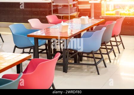 Plastic chairs and wooden tables with colored bright ceramic tiles in squares Stock Photo