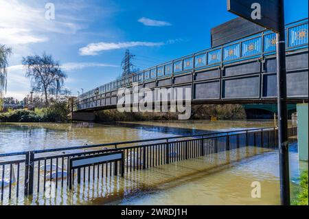 A view along a footbridge across the River Nene in Peterborough, UK on a bright sunny day Stock Photo