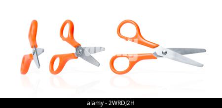 Stationery scissors collection. Three isolated scissors with orange handle on white background. School or office cutters with rings handles. Kids crea Stock Photo