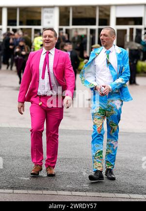 Racegoers Ash Robinson (left) and Paul Norfolk wearing colourful suits during day one of the 2024 Cheltenham Festival at Cheltenham Racecourse. Picture date: Tuesday March 12, 2024. Stock Photo