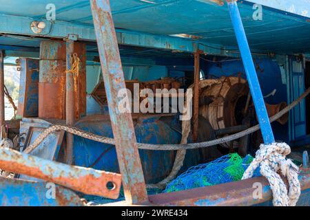 The covered deck of an old abandoned trawler in the marina at Roccella Ionica, Calabria, southern Italy Stock Photo