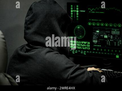 young professional female hacker using keyboard typing bad data into computer online system and spreading to global stolen personal information. Stock Photo