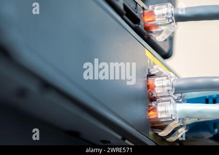 Network Gigabit Smart PoE Switch with  connected network cables getting tested on the desk Stock Photo