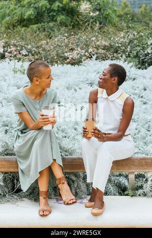 Two businesswomen are having coffee in the park. Stock Photo