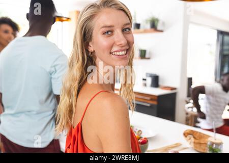 Young Caucasian woman in a red top smiles at a social gathering Stock Photo