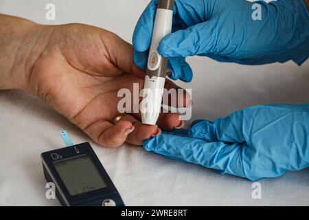 Doctor measuring blood sugar level of diabetic patient in clinic Stock Photo