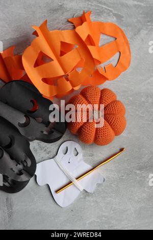 Flat lay composition with knitting accessories on grey background. Handmade decorations for Halloween. Space for text. Stock Photo