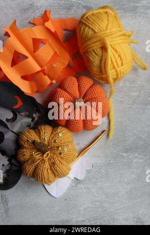 Flat lay composition with knitting accessories on grey background. Handmade decorations for Halloween. Space for text. Stock Photo