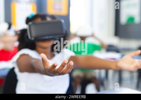 A student is experiencing virtual reality in a classroom setting in school Stock Photo