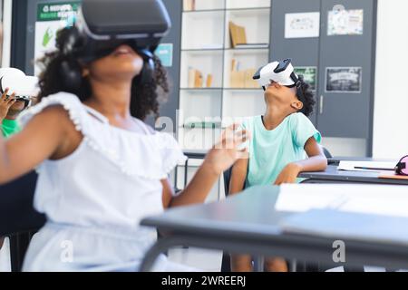 Biracial children are exploring virtual reality in a classroom setting in school Stock Photo