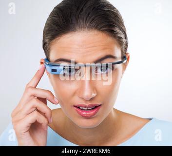 Portrait, woman or smart glasses for augmented reality, metaverse or serious in studio isolated on white background. Face, cyber eyewear or future Stock Photo
