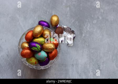 Vibrant colors of Easter sweets. Colorful still life with white gypsophila flowers and chocolate eggs. Stock Photo