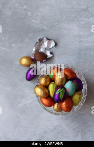 Vibrant colors of Easter sweets. Colorful still life with white gypsophila flowers and chocolate eggs. Stock Photo