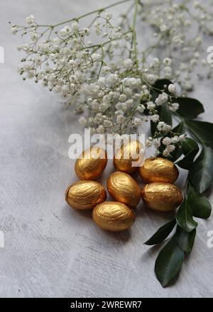 Chocolate eggs wrapped in a foil top view photo. Still life with Easter sweets on a table. Stock Photo
