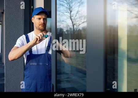 worker installing and adjusting aluminum frame sliding terrace doors Stock Photo