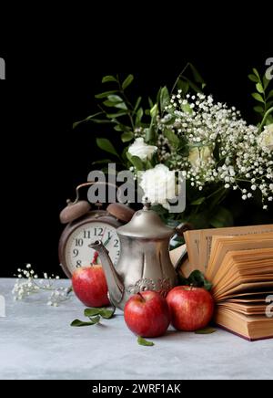 Retro styled still life with an open book on a desk. Close up photo of vintage objects. Stock Photo