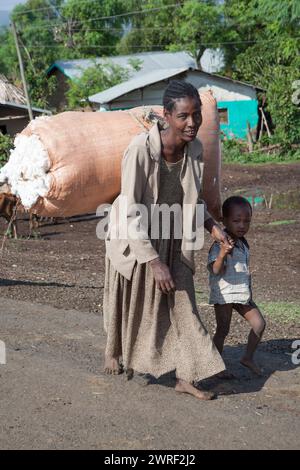 SOUTH OMO - ETHIOPIA - NOVEMBER 19, 2011: The woman with the son come back from work on a cotton plantation, Africa., in November 19, 2011 in Omo Rift Stock Photo