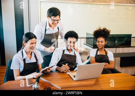 Diverse entrepreneurs in stylish coffee shop have a team meeting. Barista owner discuss work on Stock Photo