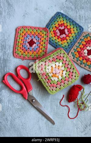 Crochet project in making. Colorful crochet squares close up photo. Hand made top in process. Stock Photo