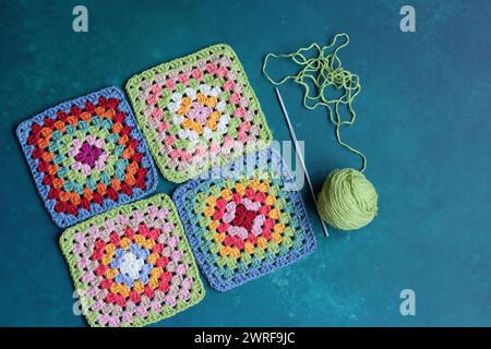 Handmade crocheting, needlework and handicraft concept. Rainbow colored granny squares close up photo. Crochet texture. Stock Photo